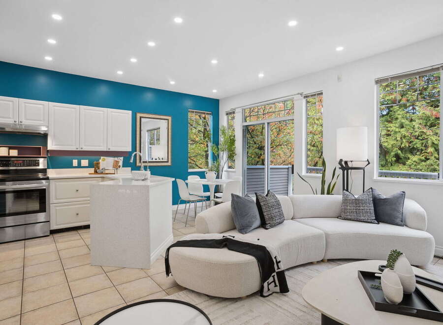 Experience modern living in this open-concept space featuring a sleek kitchen with white cabinetry and a stylish island, perfect for entertaining.