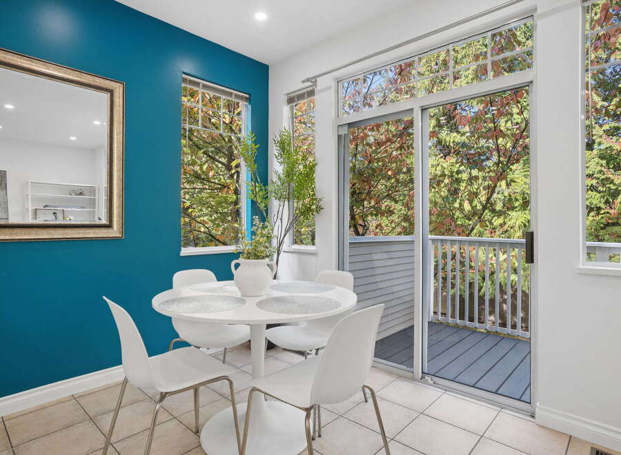 Enjoy bright and airy dining with this charming space, featuring a sleek white tulip table and chairs perfect for intimate meals.