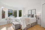 Bright and airy bedroom featuring a comfortable queen-size bed with plush pillows and a cozy throw blanket.