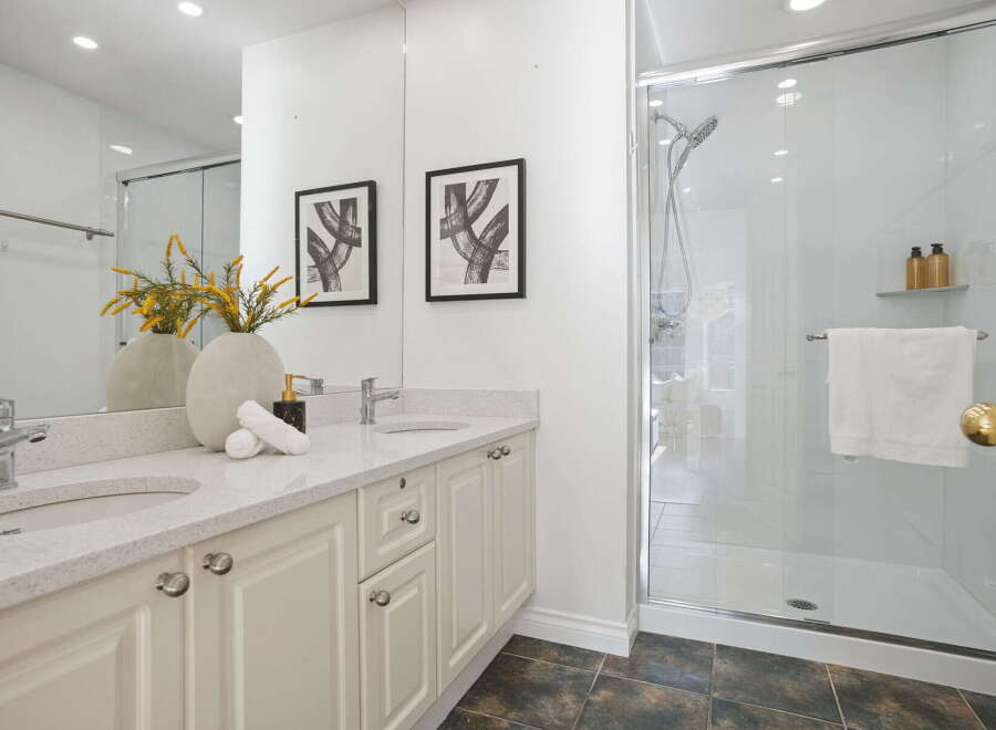 This modern bathroom features a spacious double vanity with ample counter space and elegant cabinetry.