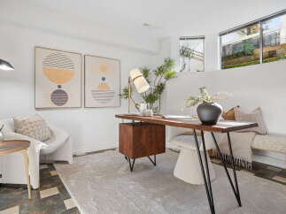 Discover a stylish and functional home office space featuring a modern wooden desk with a unique cabinet and sleek metal legs.