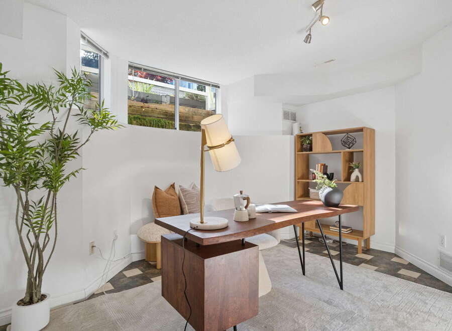 This home office features a stylish wooden desk with a modern lamp and a coffee maker, perfect for productivity.
