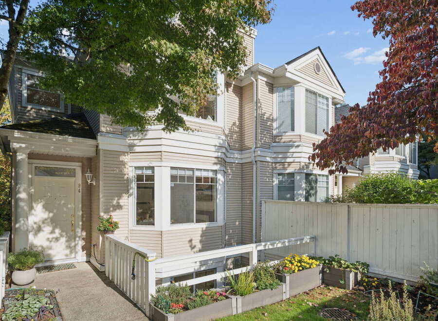 Charming townhouse with a welcoming entrance, featuring a white door and a covered porch.