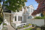 Charming townhouse with a welcoming entrance, featuring a white door and a covered porch.