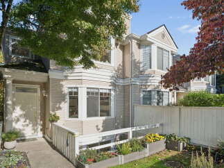 Charming townhouse with a welcoming entrance, featuring a white door and a covered porch.