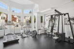 Elevate your fitness routine in this well-equipped home gym, featuring a treadmill, elliptical, stationary bike, and a comprehensive weight machine.