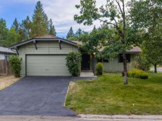Charming single-story home with a light green exterior and a single-car garage.