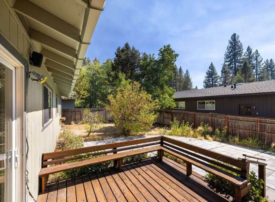 Enjoy outdoor living on this charming wooden deck, complete with built-in benches perfect for relaxing.