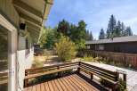Enjoy outdoor living on this charming wooden deck, complete with built-in benches perfect for relaxing.