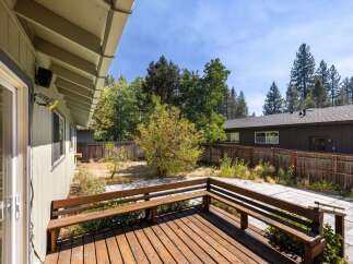 Enjoy outdoor living on this charming wooden deck, complete with built-in benches perfect for relaxing.