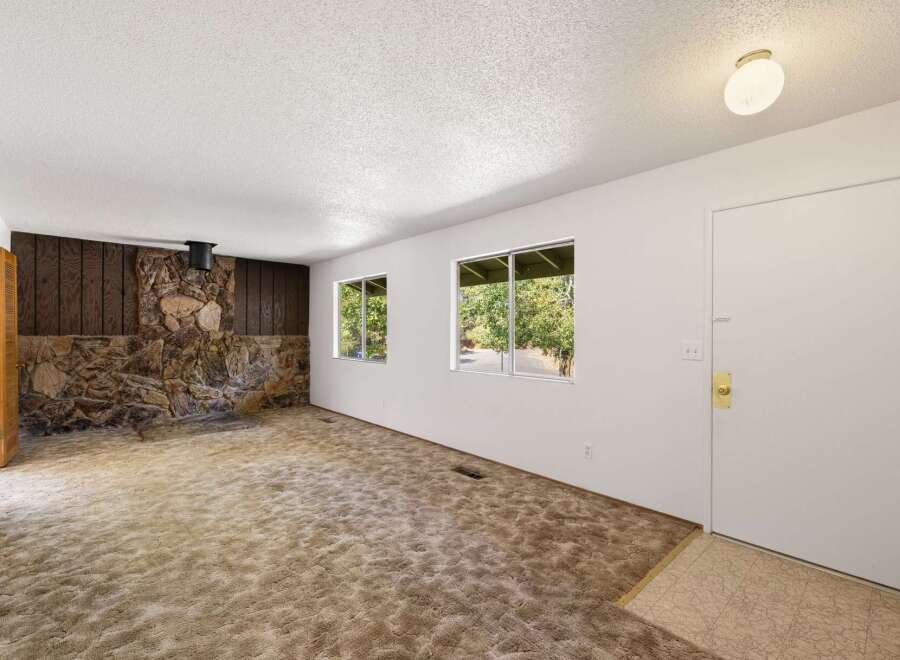 Step into this charming living space featuring a striking stone fireplace as the focal point, perfect for cozy evenings.