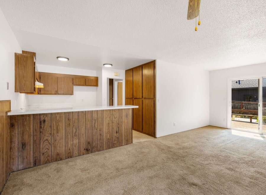 This spacious living area features a functional kitchen with ample cabinet space and a breakfast bar, perfect for casual dining.