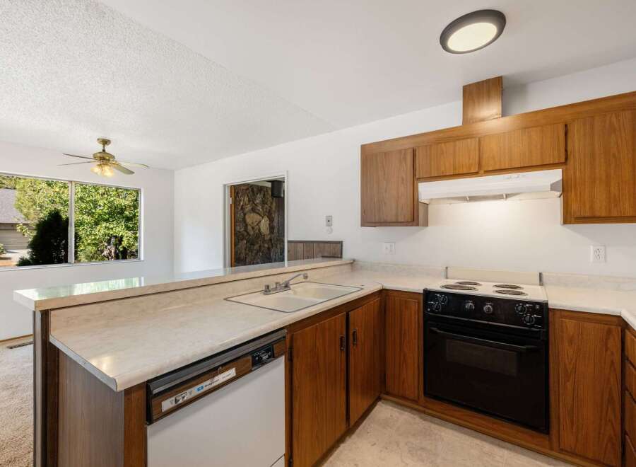 This charming kitchen features warm wooden cabinetry and a spacious countertop with a double sink.