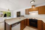 This charming kitchen features warm wooden cabinetry and a spacious countertop with a double sink.