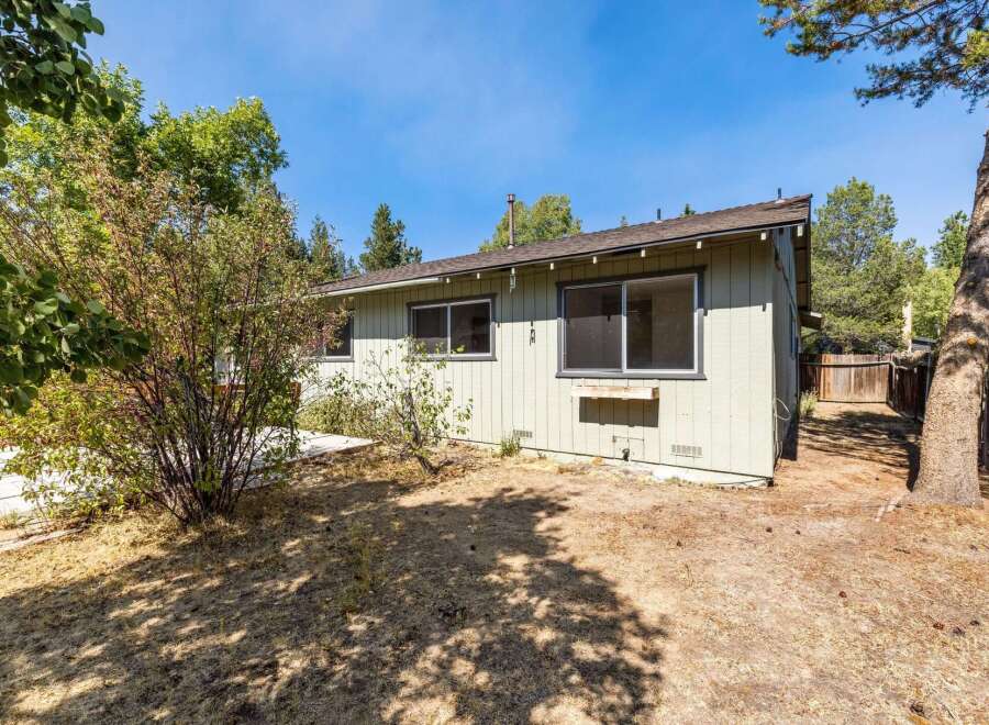 Discover this charming home featuring a light green exterior and a spacious backyard.