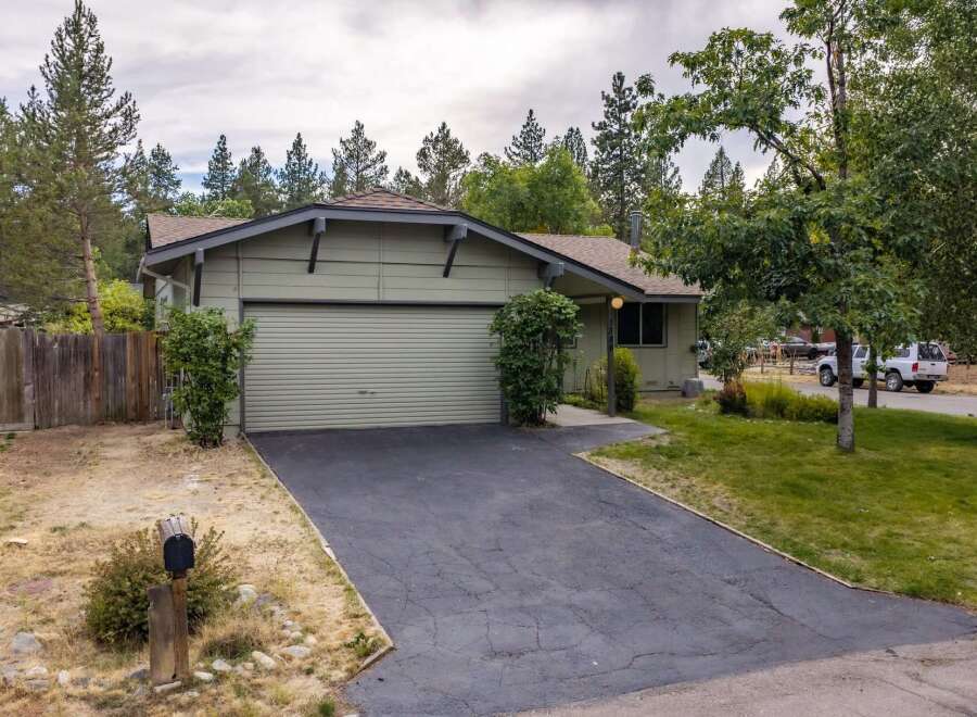 Discover this charming single-family home featuring a light green exterior and a spacious attached garage.