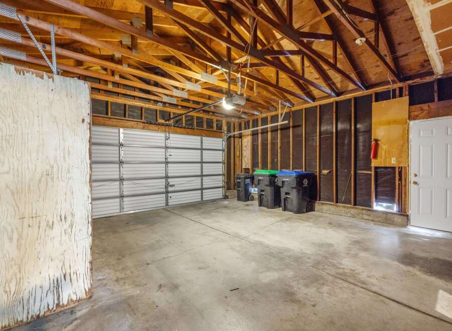 This spacious garage offers ample room for vehicles and storage, featuring a durable concrete floor and a sturdy overhead door.