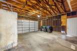 This spacious garage offers ample room for vehicles and storage, featuring a durable concrete floor and a sturdy overhead door.