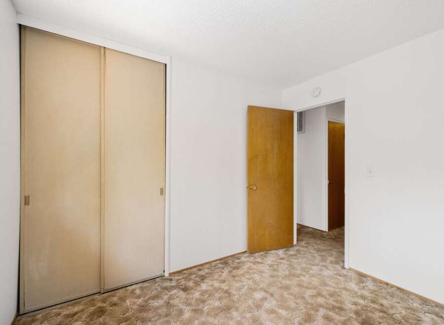 Step into this inviting bedroom, featuring a spacious closet with sliding doors, perfect for ample storage.