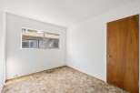 This room features a large window offering a view of the exterior and a classic wooden door with a brass knob.