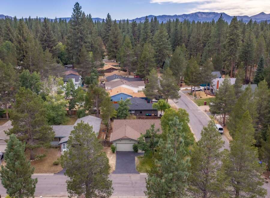 Discover this charming home nestled amongst towering pine trees, offering a serene and private retreat.