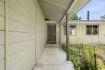 Discover the inviting entrance to this charming home, featuring a covered walkway leading to a welcoming front door.