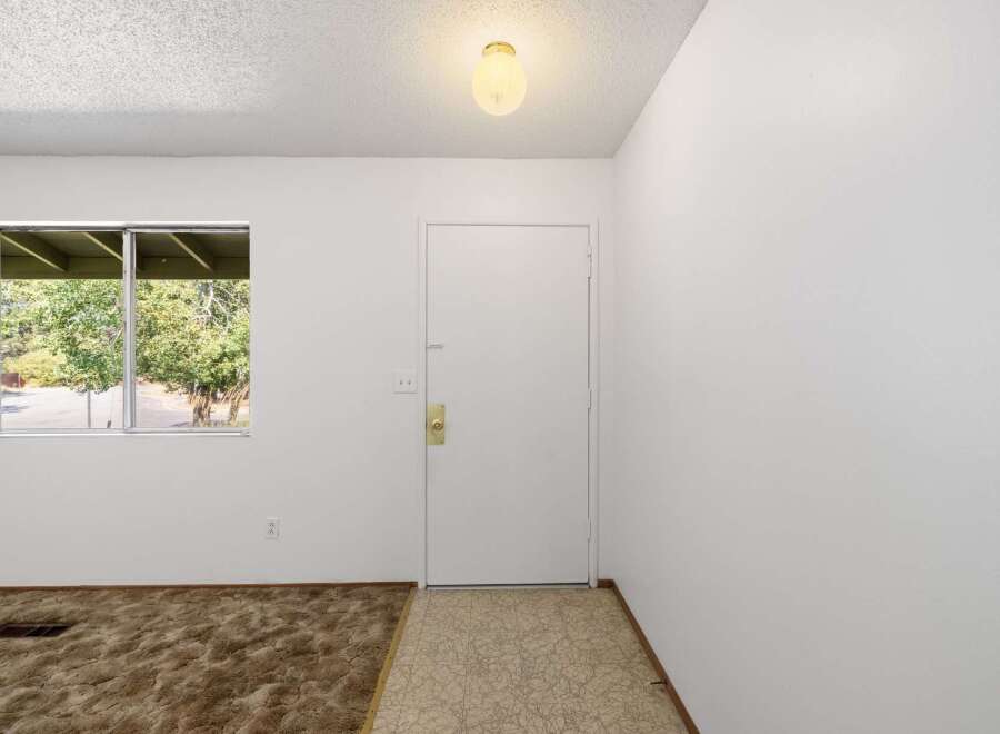 Step into this inviting space featuring a large window that floods the room with natural light, offering picturesque views of the surrounding greenery.