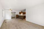 Step into this inviting living space featuring plush carpeting and a ceiling fan for year-round comfort.