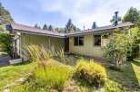 Discover this charming single-story home nestled amongst mature trees, offering a serene and private setting.