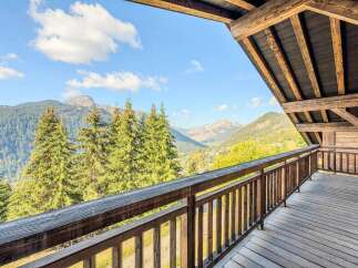Experience breathtaking mountain vistas from the expansive wooden balcony of this charming alpine property.