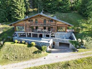 Experience luxury mountain living in this stunning chalet, nestled amidst a serene forest.