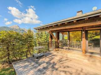 Experience breathtaking mountain views from this charming wooden chalet's expansive deck.
