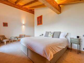 Experience rustic charm in this inviting bedroom, featuring exposed wooden beams and a cozy ambiance.