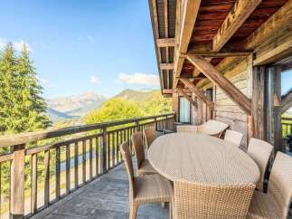 Enjoy breathtaking mountain views from this charming wooden balcony, perfect for al fresco dining or morning coffee.