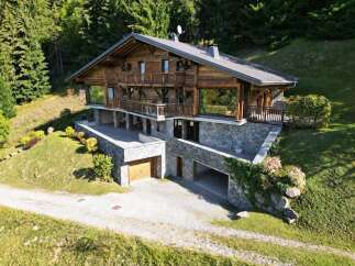 Experience luxury mountain living in this stunning chalet, nestled amidst a lush forest.