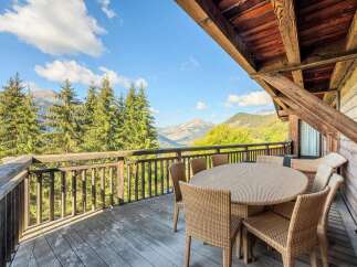 Enjoy breathtaking mountain views from this charming wooden balcony, perfect for al fresco dining or morning coffee.
