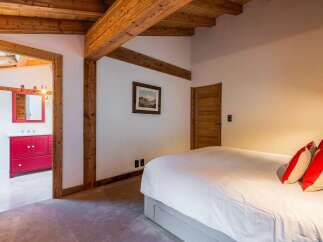 Experience rustic charm in this inviting bedroom, featuring exposed wooden beams and a cozy ambiance.