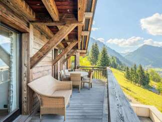 Experience breathtaking mountain views from this charming wooden chalet's expansive balcony.