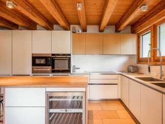 Experience modern living in this stunning kitchen featuring sleek white cabinetry and integrated stainless steel appliances, including a microwave and double ovens.