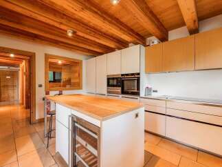 Experience luxury living in this modern kitchen featuring a spacious island with a built-in wine cooler, perfect for entertaining.