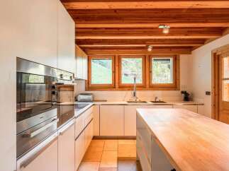 Experience modern living in this stunning kitchen, featuring sleek white cabinetry and integrated Miele appliances.