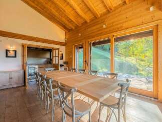 Experience rustic charm and modern comfort in this spacious dining area, featuring a large wooden table perfect for family gatherings.