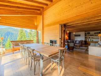 Experience luxury mountain living in this stunning dining room, featuring a large wooden table and chairs perfect for family gatherings.