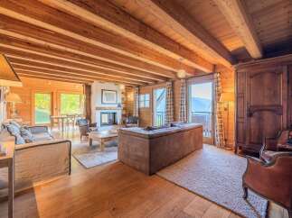 Experience the epitome of alpine living in this stunning chalet, featuring a spacious open-plan living area with a cozy fireplace and breathtaking mountain views.