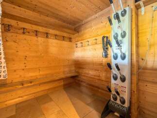 Experience ultimate convenience in this ski boot drying room, featuring a dedicated boot dryer and ample coat hooks.
