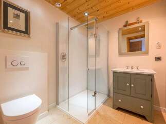 Experience modern comfort in this beautifully appointed bathroom, featuring a spacious glass-enclosed shower and a stylish vanity with ample storage.