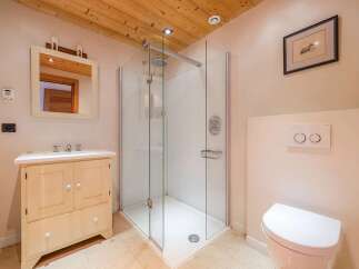 This modern bathroom features a spacious glass-enclosed shower with a rainfall showerhead, perfect for a relaxing experience.