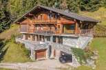 Nestled amidst lush greenery and towering trees, this magnificent wooden chalet offers an idyllic retreat.