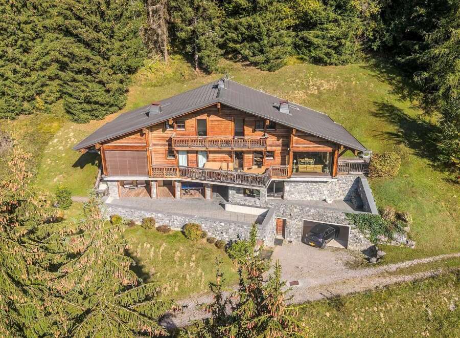 Experience luxury mountain living in this stunning wooden chalet, nestled amidst a serene forest landscape.