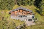 Experience luxury mountain living in this stunning wooden chalet, nestled amidst a serene forest landscape.